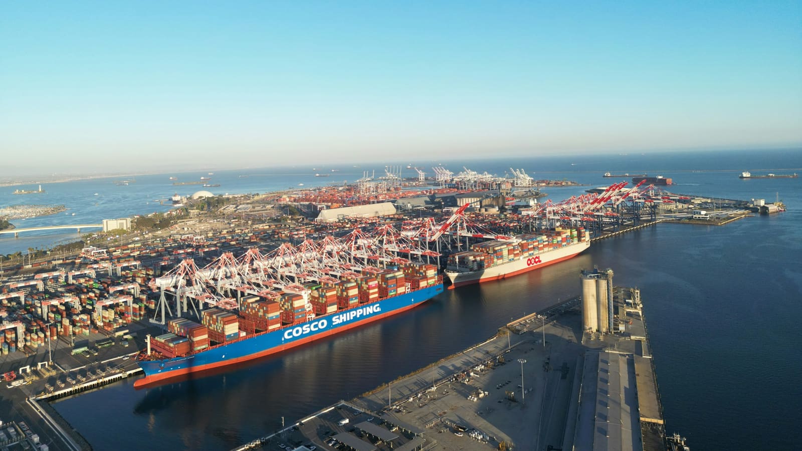 Aerial view of a container ship berthed at a busy sea port terminal
